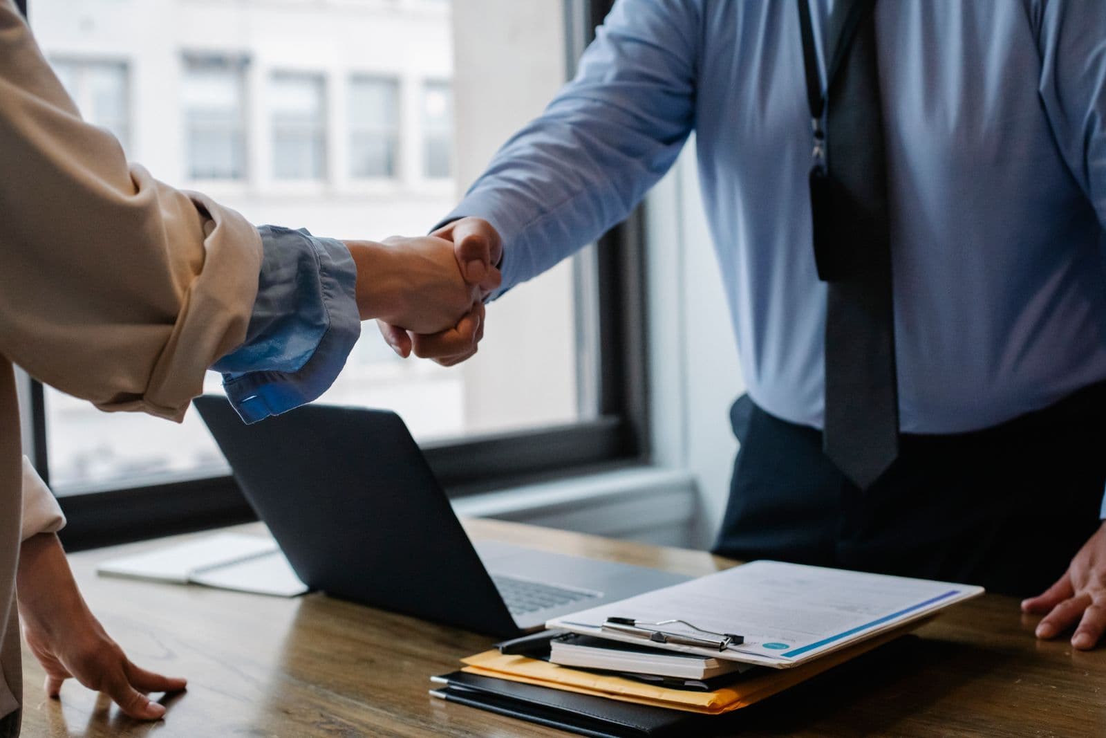 A handshake over the table — terms agreed before proceedings are issued