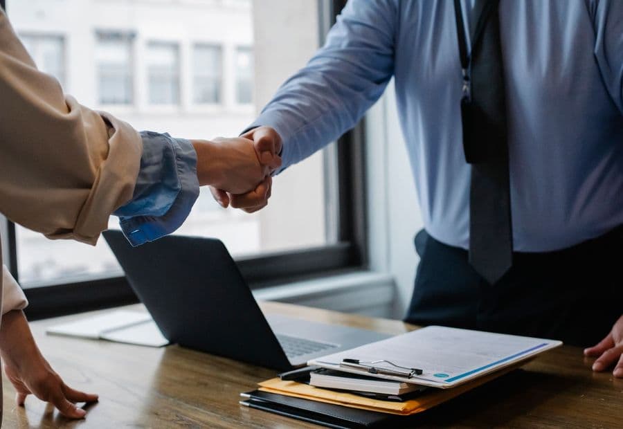 A handshake over the table — terms agreed before proceedings are issued